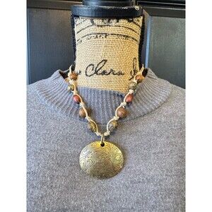 bohemian-style necklace featuring a large, embossed brass pendant & Wood beads